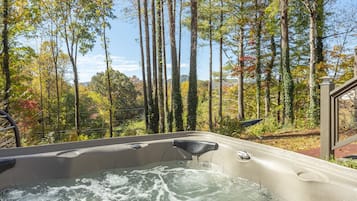 Relax in a serene hot tub surrounded by tall trees and a tranquil natural view.