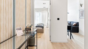 Un salon moderne comprenant un canapé, une table basse et un coin repas avec des chaises.