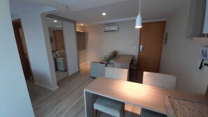 Een modern appartement met een eethoek, een bank en een keuken.