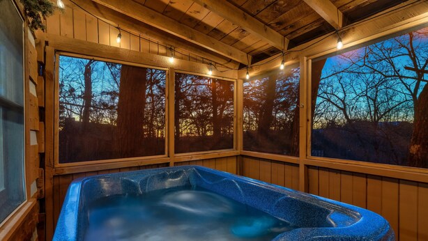 A hot tub with a view of trees through wooden-framed windows. - Secluded Mountain Getaway - Spring Sale (Sevierville)