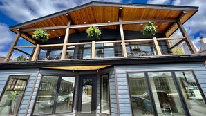 A two-story building with a wooden balcony and large windows. - BRAND NEW, WALK EVERYWHERE! Amazing Views & Luxury in the Heart of Lake Placid (Lake Placid)