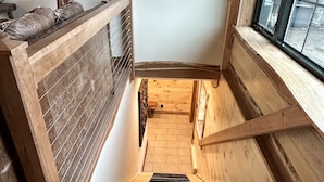A wooden staircase with a handrail, leading to a landing with a window. - BRAND NEW, WALK EVERYWHERE! Amazing Views & Luxury in the Heart of Lake Placid (Lake Placid)
