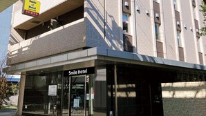 A hotel with a modern design, featuring a prominent entrance with a glass facade and a signboard above the entrance. - Smile Hotel Kokura (Kitakyushu)