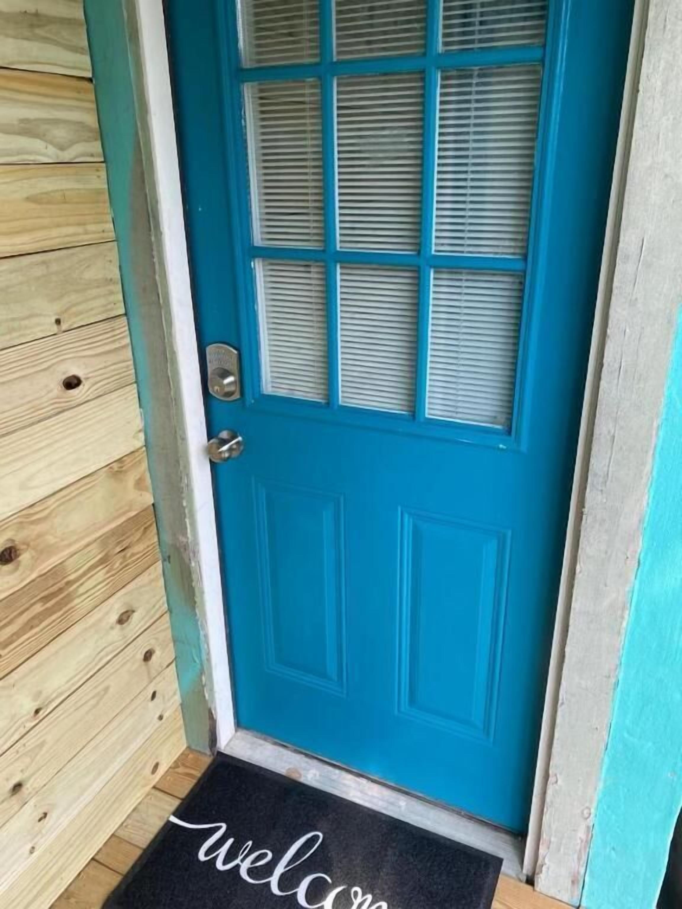 A blue door with a welcome mat at the entrance.