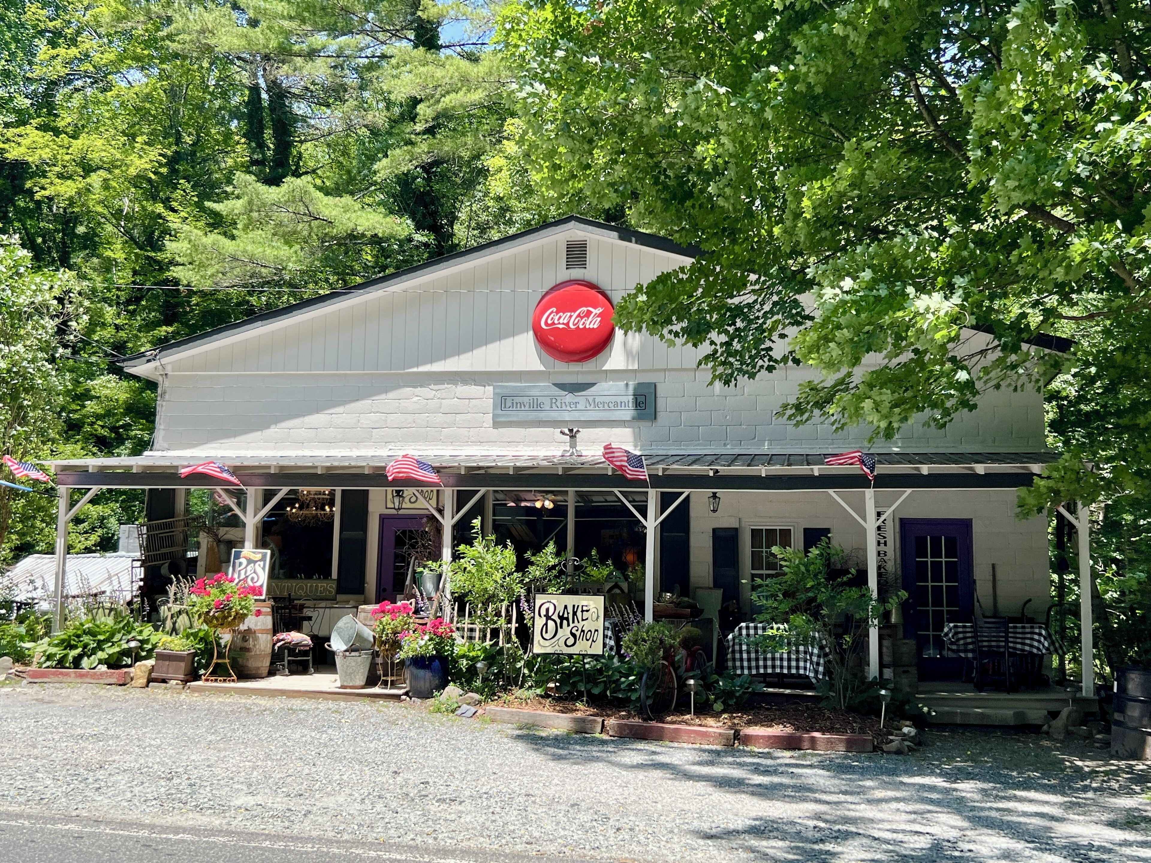 Un bâtiment orné d’une enseigne Coca-Cola, d’une enseigne pour le magasin Linville River Mercantile et d’une enseigne pour une boulangerie-pâtisserie.
