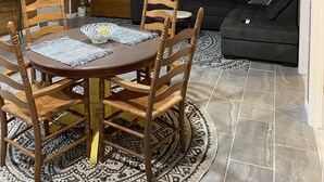 A dining area with a round table and wooden chairs, a ceiling fan, and a clock on the wall. - MT. Hideaway 2 bedroom, Lg. parking, .straight across from Buffalo MT. Trail 14 (Delbarton)