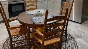 A kitchen with white cabinets, a stainless steel refrigerator, a stove, and a dining table with chairs. - MT. Hideaway 2 bedroom, Lg. parking, .straight across from Buffalo MT. Trail 14 (Delbarton)