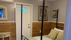 A bedroom with a four-poster bed, wooden paneling on the walls, a ceiling fan, and a small table. - MT. Hideaway 2 bedroom, Lg. parking, .straight across from Buffalo MT. Trail 14 (Delbarton)