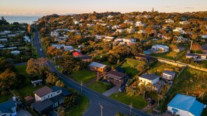 Vista aérea de uma área residencial com casas, ruas e áreas verdes.