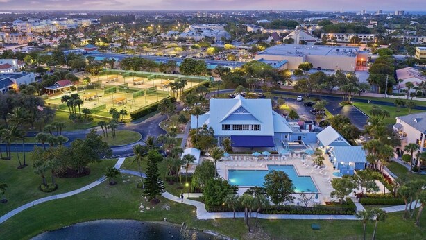 An aerial view of a large property with a swimming pool, tennis courts, and a large building with a blue roof. - Jupiter Dreams at Jupiter Bay! 2 bedroom, 2.5 bath Condo. Close to the beach!  (Jupiter)