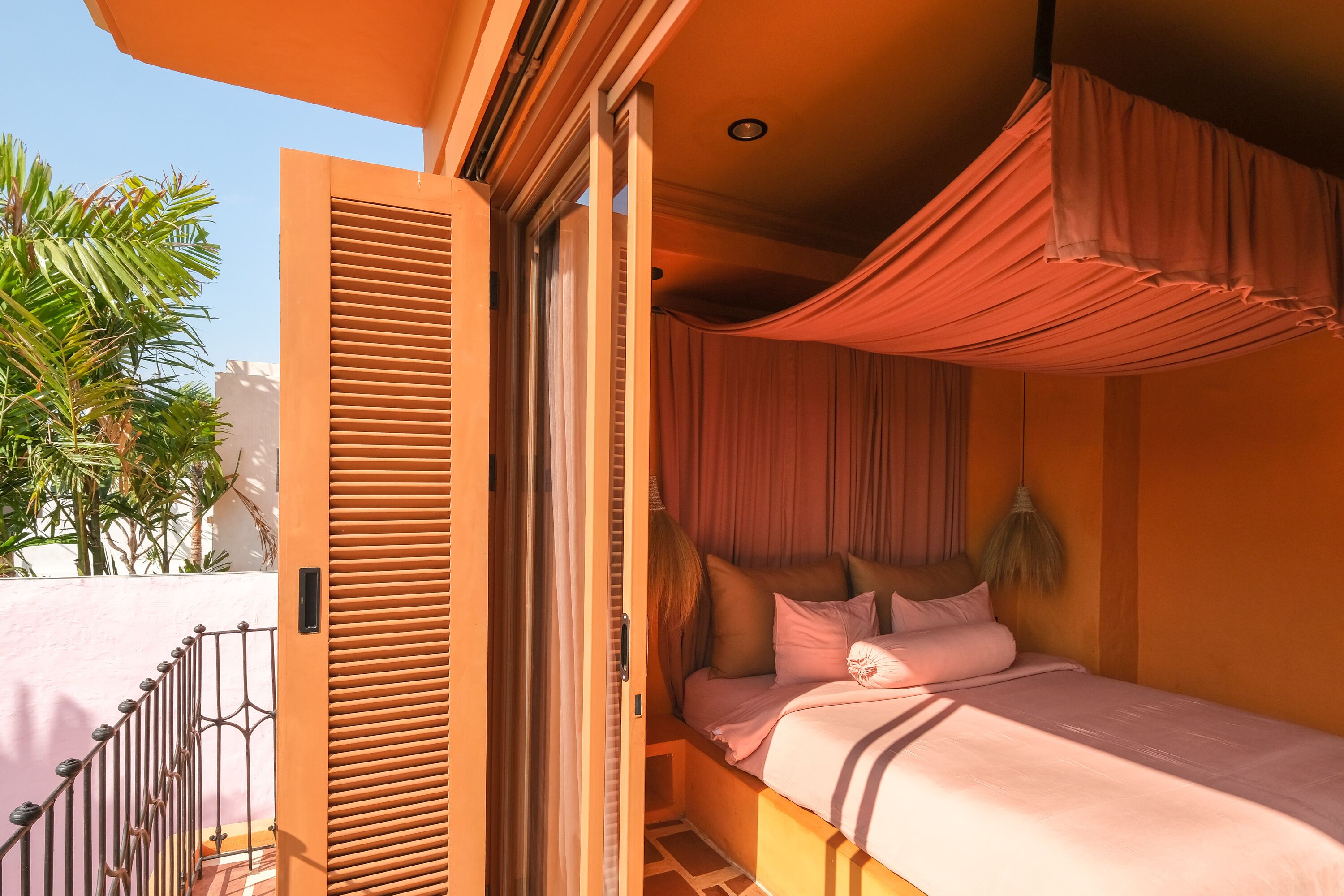 A bedroom with a bed, curtains, and a view of the outside.