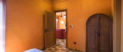 Una habitación de hotel con una cama, un armario y una puerta que da a otra habitación.