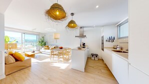 Un appartement moderne comprenant une cuisine, un coin repas et un salon.