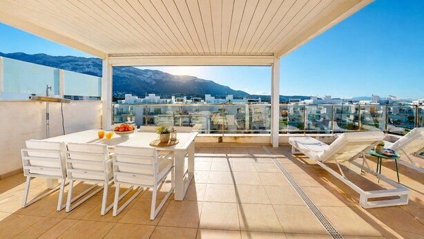 Une terrasse sur le toit équipée d’une table à manger, de chaises et d’un espace détente.