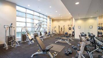 A gym with various exercise equipment, large windows, and a clean, modern design.