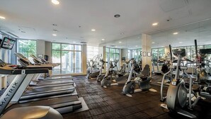 Een fitnessruimte met loopbanden, elliptische trainers en gewichtstoestellen.