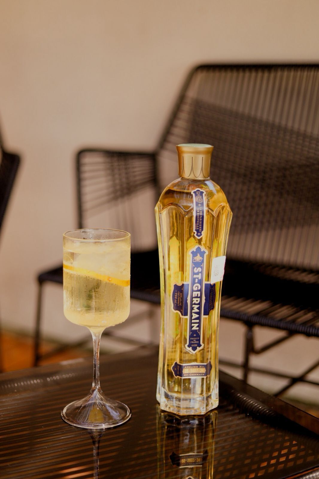 A bottle of St. Germain wine and a glass of wine on a table.