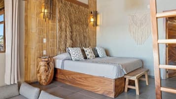A modern bedroom with a wooden bed, a bench, a woven wall, and a macrame wall hanging.