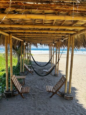 Na praia, barracas de praia de cortesia, espreguiçadeiras, guarda-sóis 
