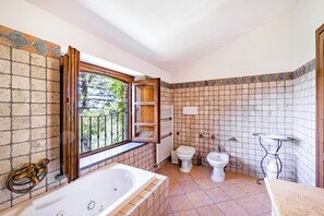 Een bad/douchecombinatie, een bubbelbad, een haardroger, een bidet