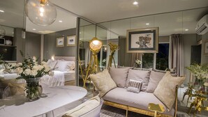 A modern bedroom with a large bed, bedside tables, a glass coffee table, and a sofa. - Bed In Town Saigon (Ho Chi Minh City)