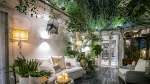 A cozy lounge area with a sofa, potted plants, and a table with candles. - Bed In Town Saigon (Ho Chi Minh City)
