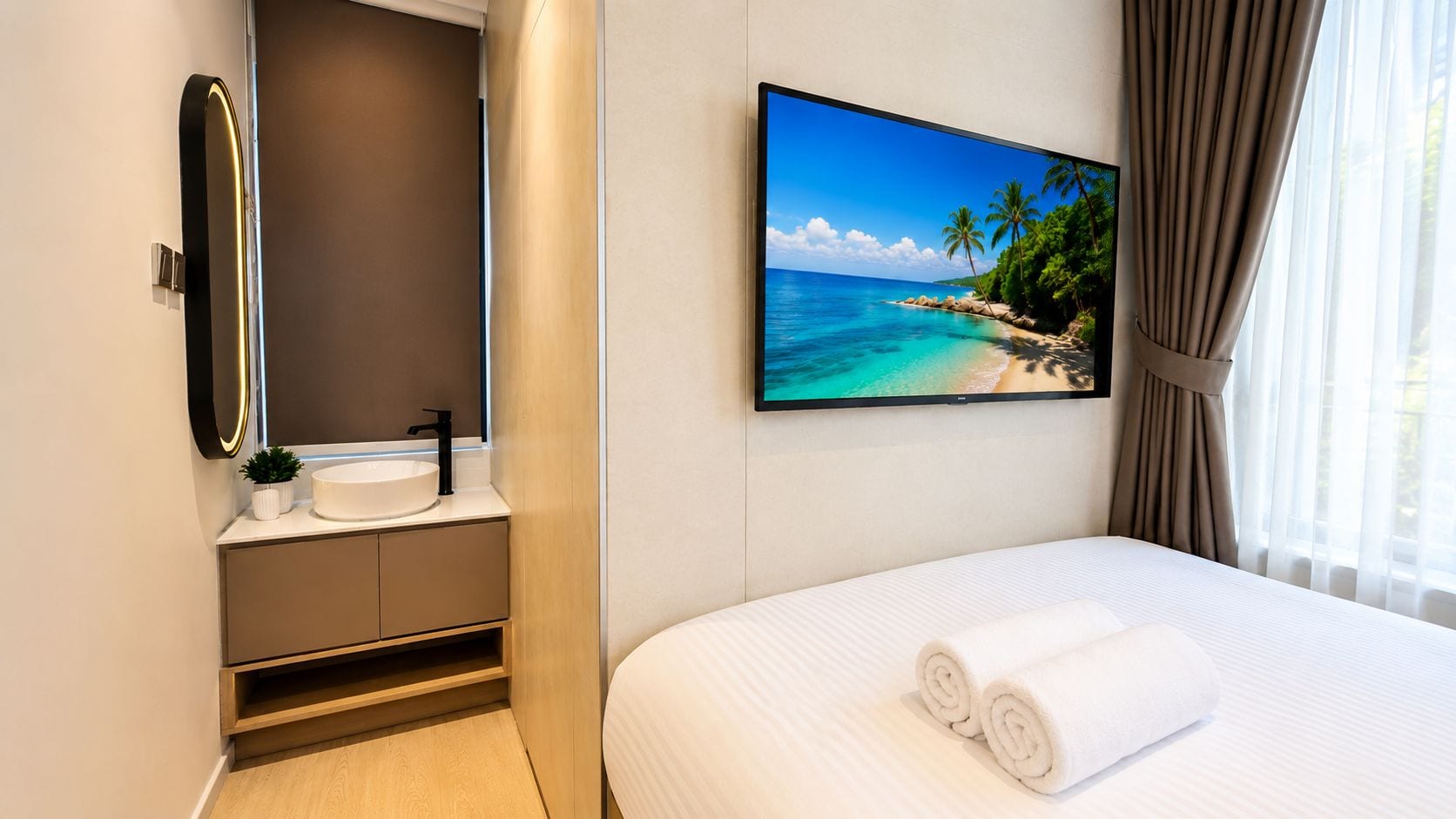 A hotel room with a bed, a bathroom with a sink, and a large window with curtains.