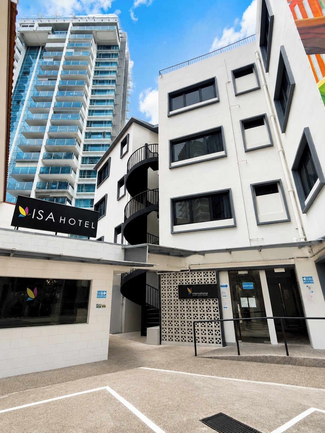 Un edificio moderno con un letrero que dice 'ISA HOTEL' y una entrada visible.