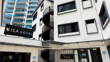 Un edificio moderno con un letrero que dice 'ISA HOTEL' y una entrada visible.