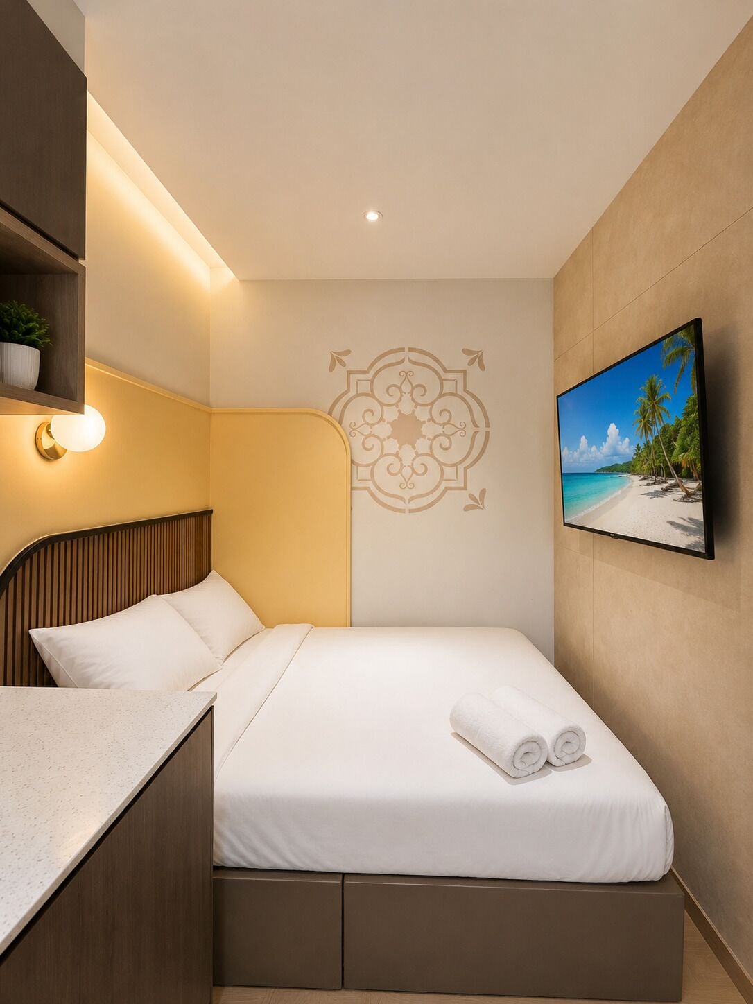 A hotel room with a bed, a wall-mounted TV, a decorative wall pattern, and a small shelf with a plant.