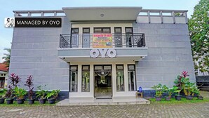 Un bâtiment sur lequel on peut lire l’inscription « OYO » et une banderole qui fait la publicité de « KERANGGA 34 KOST », avec des équipements tels que la climatisation, le Wi-Fi et la télévision.