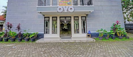 A building with a sign reading "OYO" and a banner advertising "KERANGGA 34 KOST" with amenities like AC, WIFI, and TV.