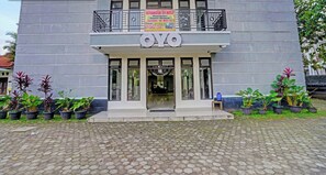 Un bâtiment sur lequel on peut lire l’inscription « OYO » et une banderole qui fait la publicité de « KERANGGA 34 KOST », avec des équipements tels que la climatisation, le Wi-Fi et la télévision.