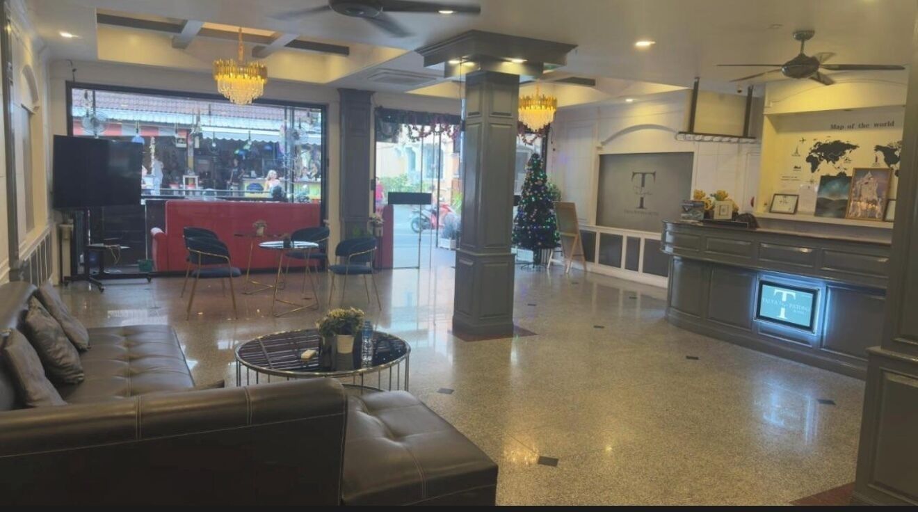 Un hall d’entrée spacieux avec un canapé en cuir, une table basse ronde et un sapin de Noël.