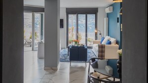 A spacious living area with a large window, a sofa, a coffee table, and a dining table. - Vista Lario in Carate Urio (Carate Urio)