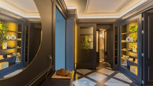 A modern hotel lobby with a check-in counter, a seating area with a laptop, and a hallway leading to a bathroom. - Vista Lario in Carate Urio (Carate Urio)
