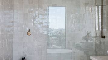 A modern bathroom with a glass-enclosed shower, a sink, and a vanity with cabinets.