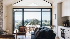 A spacious living area with a large sliding glass door leading to a balcony with a scenic view.
