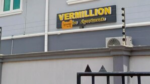 En byggnad med en skylt som visar texten ”VERMILLION Apartments” och en grind vid ingången.
