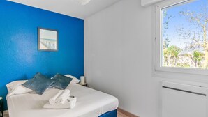 Ein Schlafzimmer mit Bett, Fenster und einem Bild an der Wand.