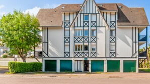Ein zweistöckiges Gebäude mit einer symmetrischen Fassade, das einen zentralen Eingang mit einer Tür und Fenstern links und rechts zeigt.