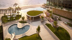 Een resort met een zwembad, terras en uitzicht op de oceaan.