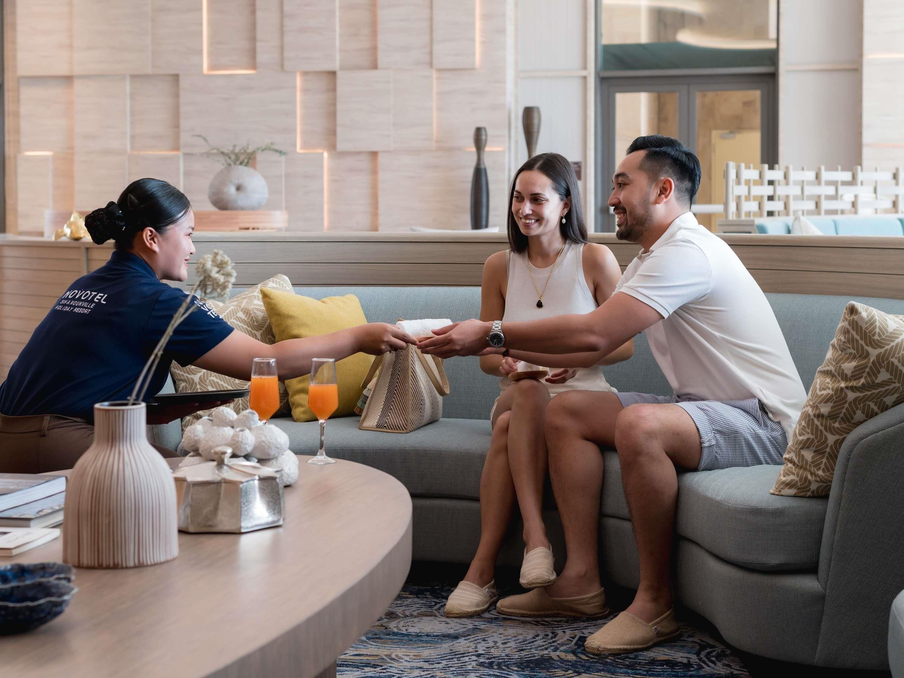 Eine Hotelhalle mit einer Rezeption, einer Couch und einem Couchtisch mit Annehmlichkeiten.