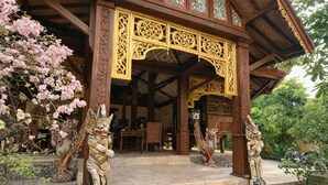 A traditional building with ornate wooden carvings, a stone staircase, and statues.