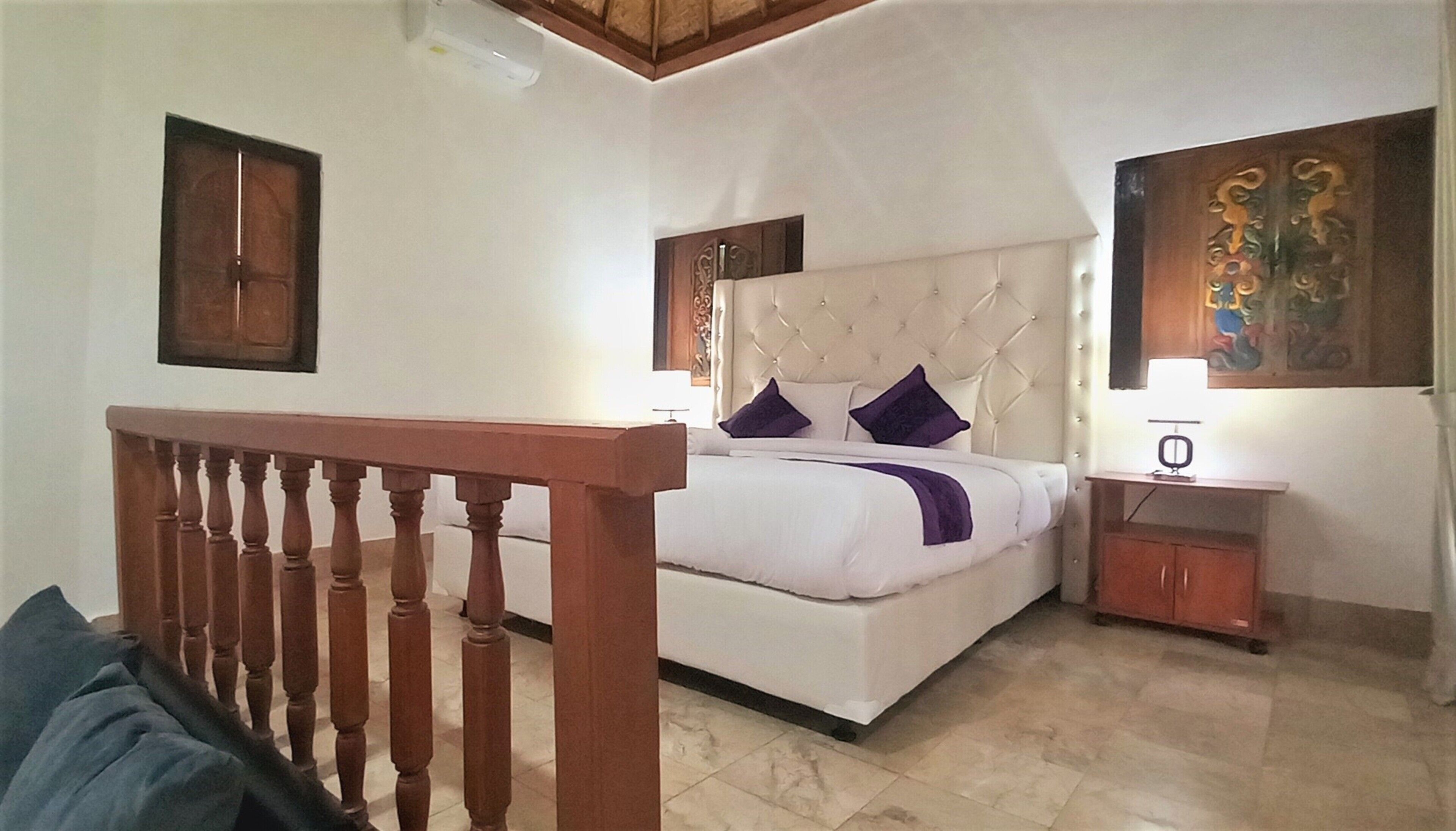 Quarto com cama, cabeceira de madeira, mesa de cabeceira e um quadro na parede.