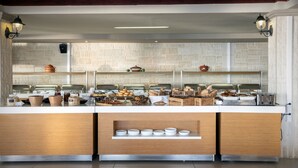 A buffet setup with various food items and serving utensils. - Alexandra Beach Hotel (Chania)