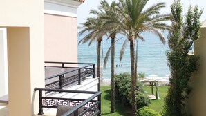 A balcony with a view of the sea, palm trees, and a tiled floor. - Alexandra Beach Hotel (Chania)