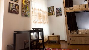 A room with a bunk bed, a desk with chairs, a chandelier, and artwork on the walls. - Old Radio  (Samarkand)