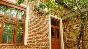 A brick building with large windows and a door, surrounded by trees. - Old Radio  (Samarkand)