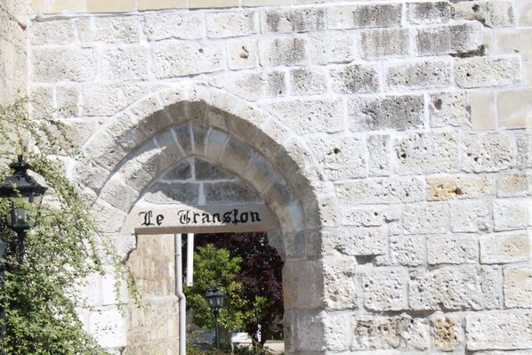 An arched stone doorway with a sign reading "Le Granglon." - Le Translon  (Saint-Pierre-Aigle)
